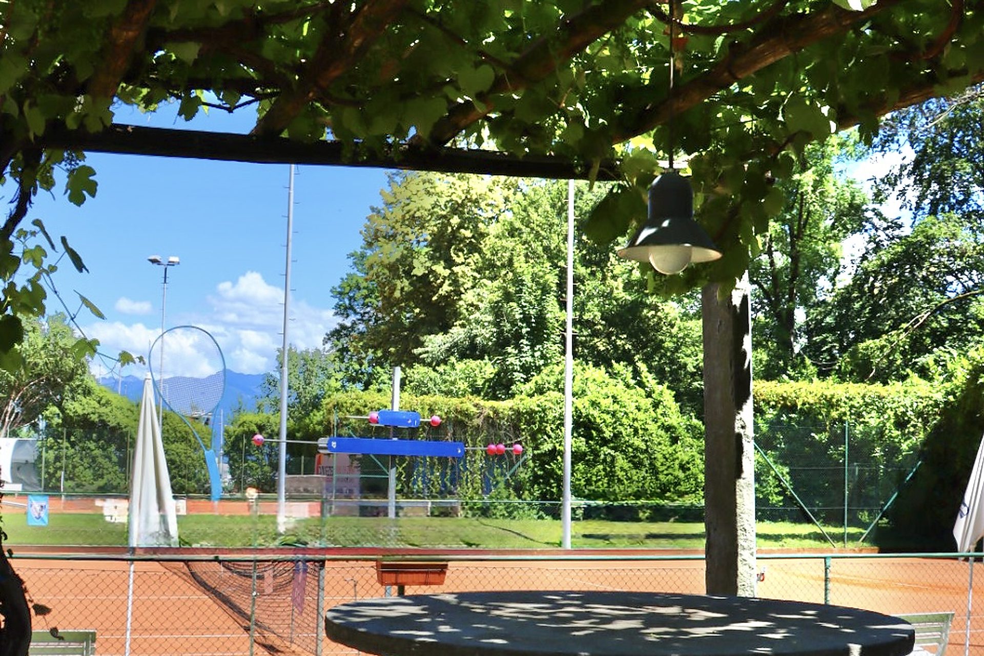 Pergolato di vite del Ristorante 23 con tavolo in pietra affacciato sui campi in terra battuta